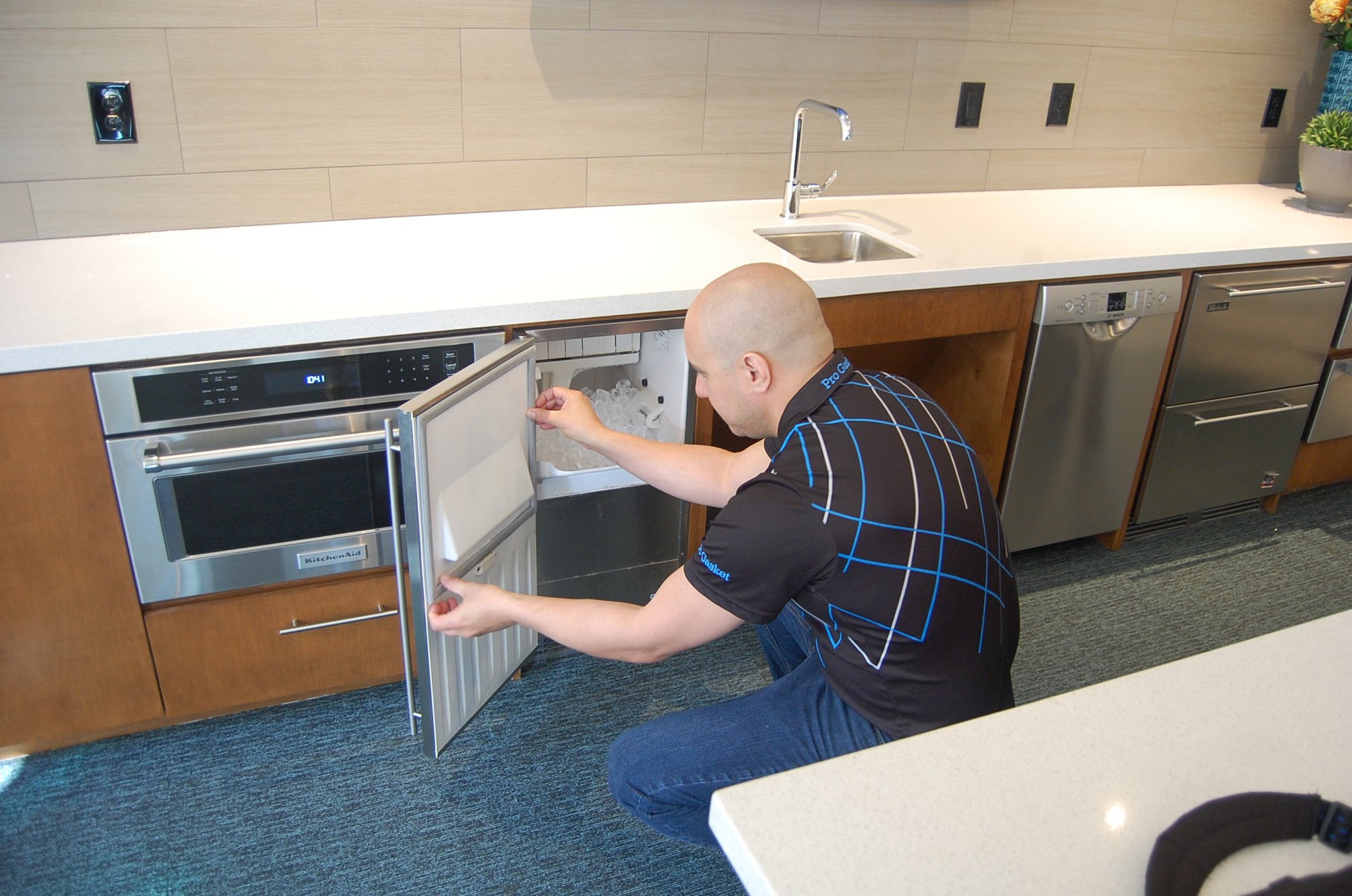 A Pro Gasket Group technician servicing refrigeration equipment in a commercial kitchen